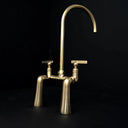 Golden arc brass bridge faucet – side view showing arc and patina