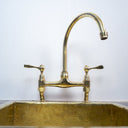 Unlacquered brass curved legs bridge faucet – high-arc spout side view
